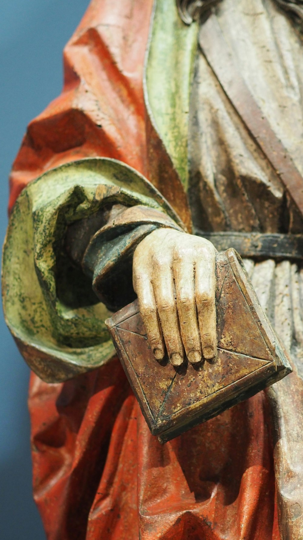 a close up of a statue of a person holding a book