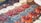 A vibrant display of assorted fruit tarts on a bright background.