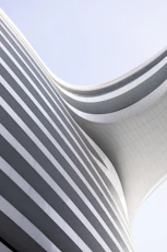a curved building with a sky background