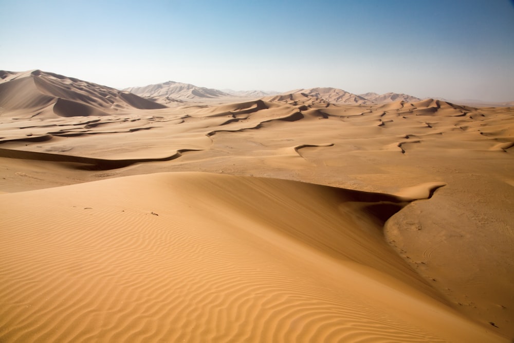 Desierto marrón bajo un cielo azul claro durante el día