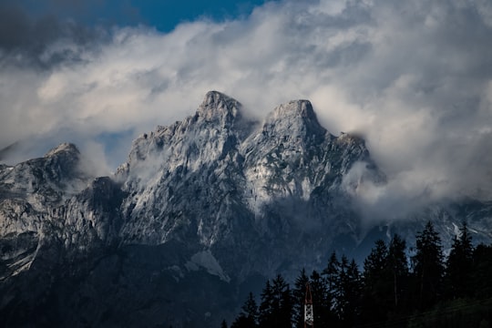 snow-capped rocky mountain surrounded by fog in Salzburg Austria