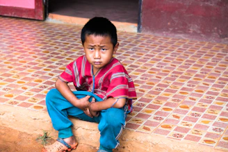 boy sitting on tiled floor