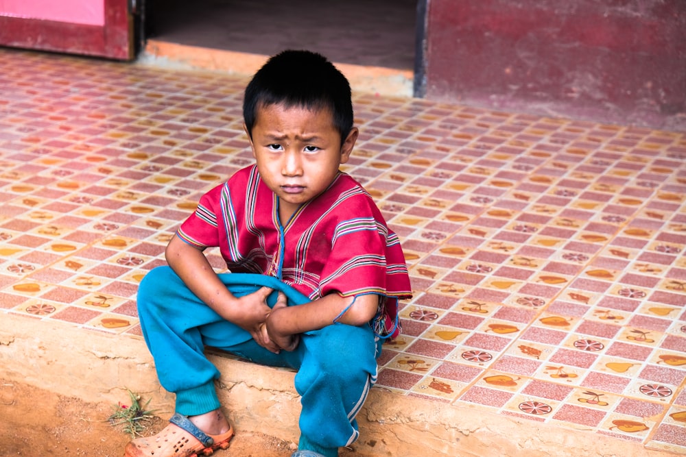 タイル張りの床に座る少年