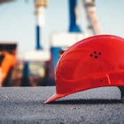 red hard hat on pavement\