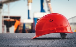 red hard hat on pavement\