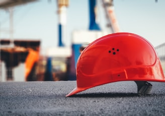 red hard hat on pavement\