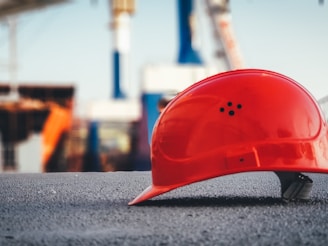 red hard hat on pavement\