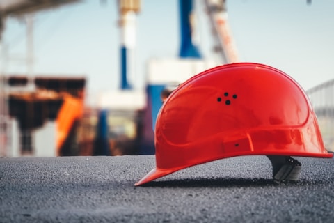 red hard hat on pavement\