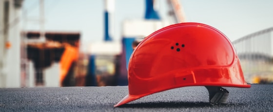 red hard hat on pavement\