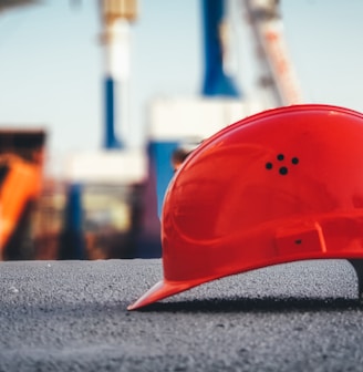 red hard hat on pavement\