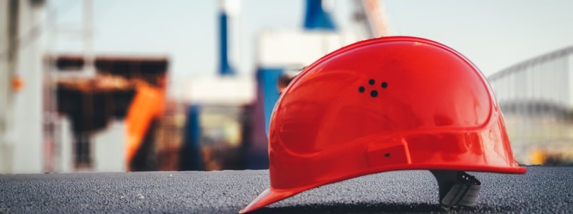 red hard hat on pavement\