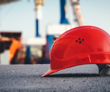 red hard hat on pavement\