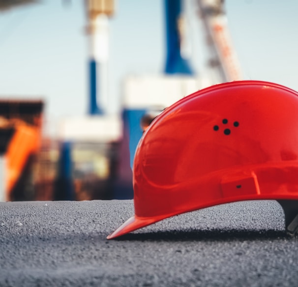 red hard hat on pavement\