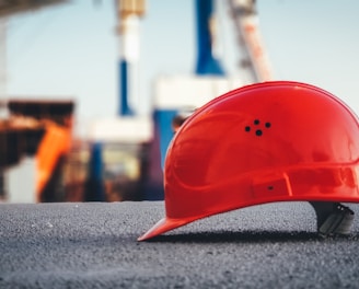 red hard hat on pavement\