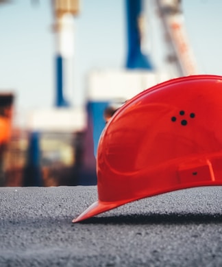 red hard hat on pavement\