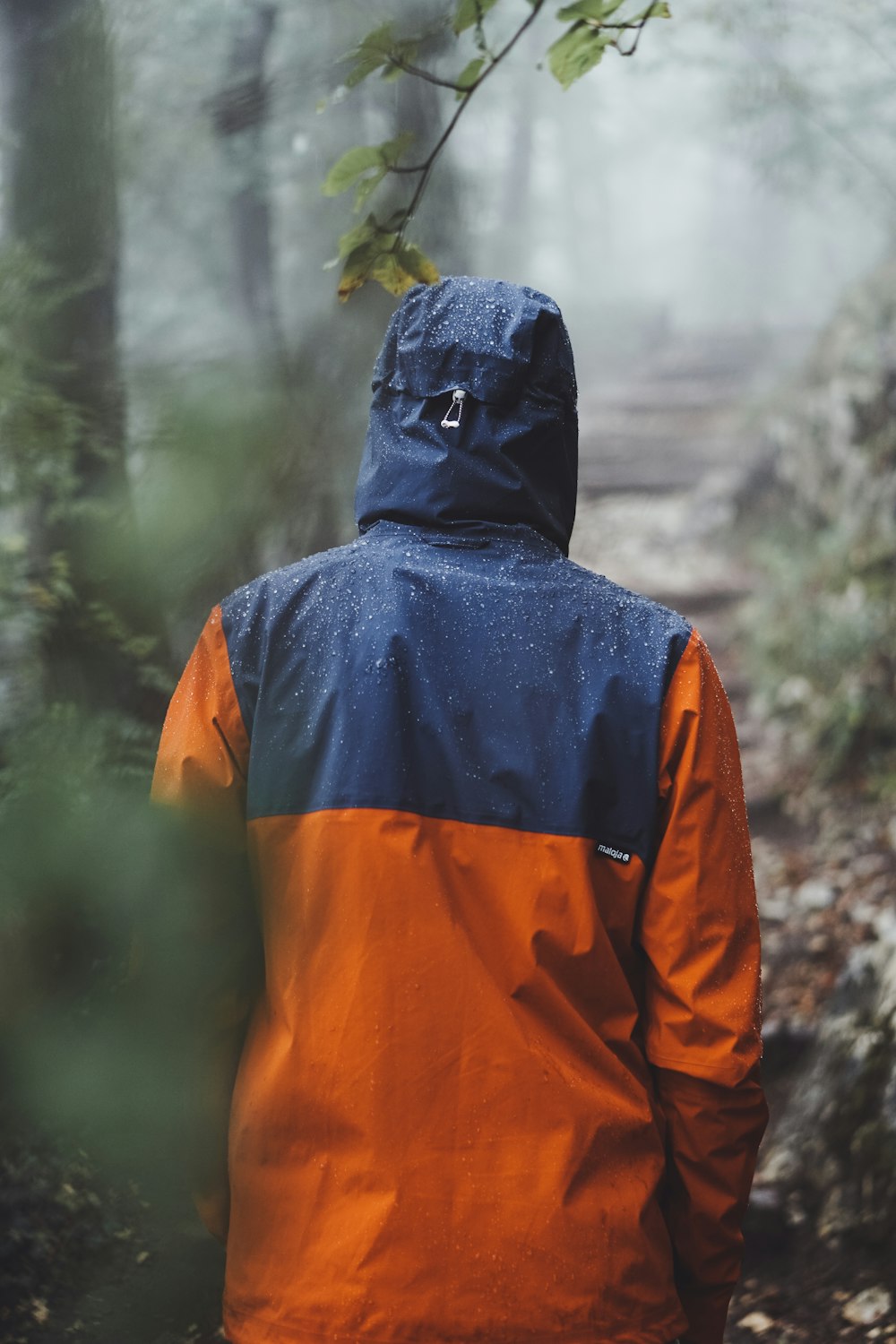 man wearing orange and blue raincoat