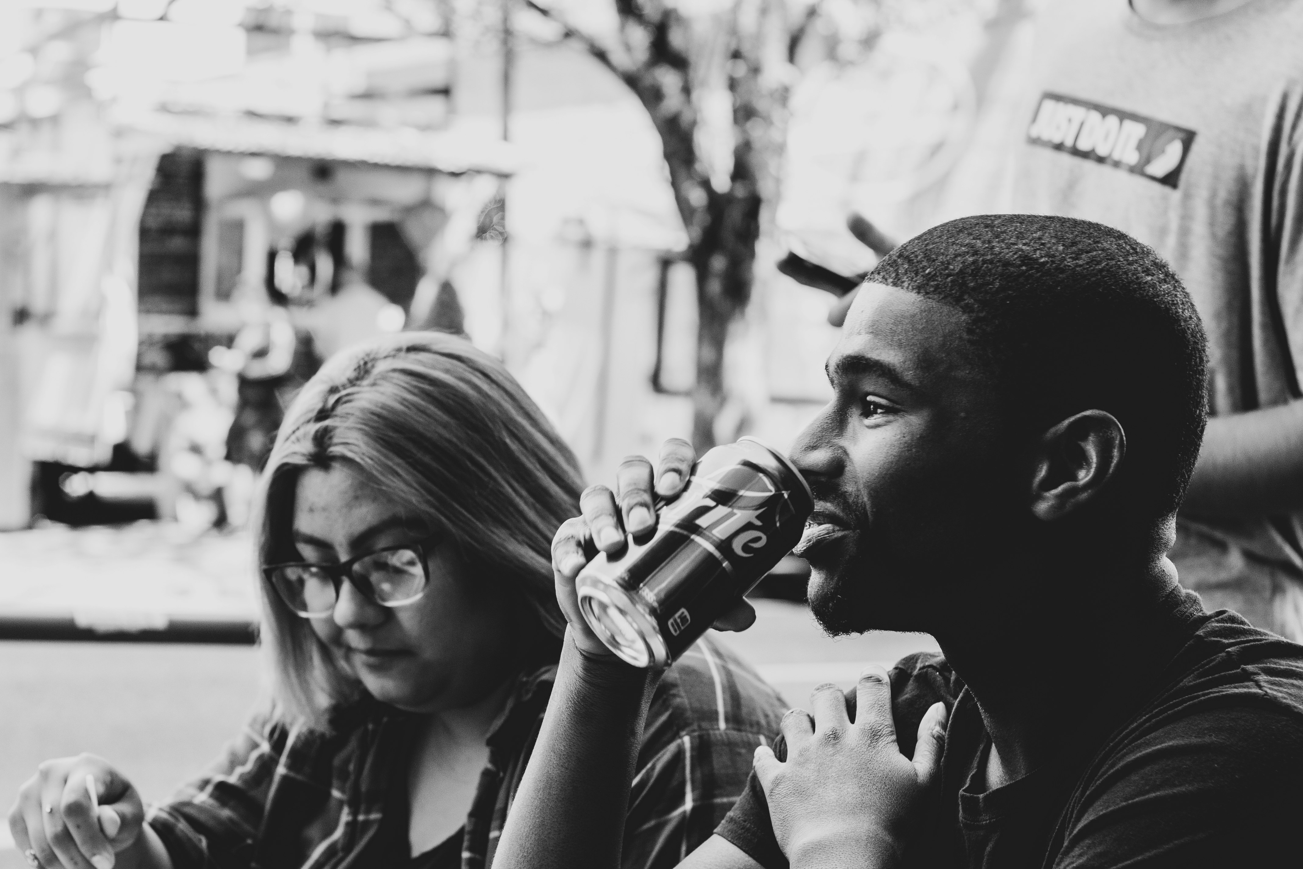 grayscale photo of man and woman sitting beside each other