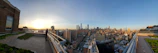 Panoramic rooftop view of downtown Delhi skyline at sunset.