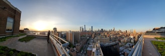 Panoramic view of a stylish penthouse suite overlooking the city skyline at sunset.