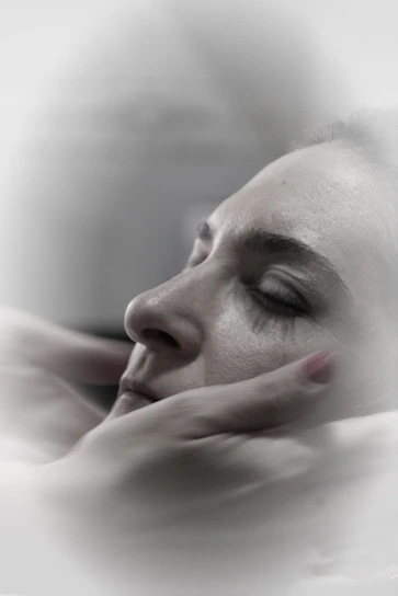 A serene photo of Jess gently placing hands over a client’s shoulders during a healing session in a cozy home setting.
