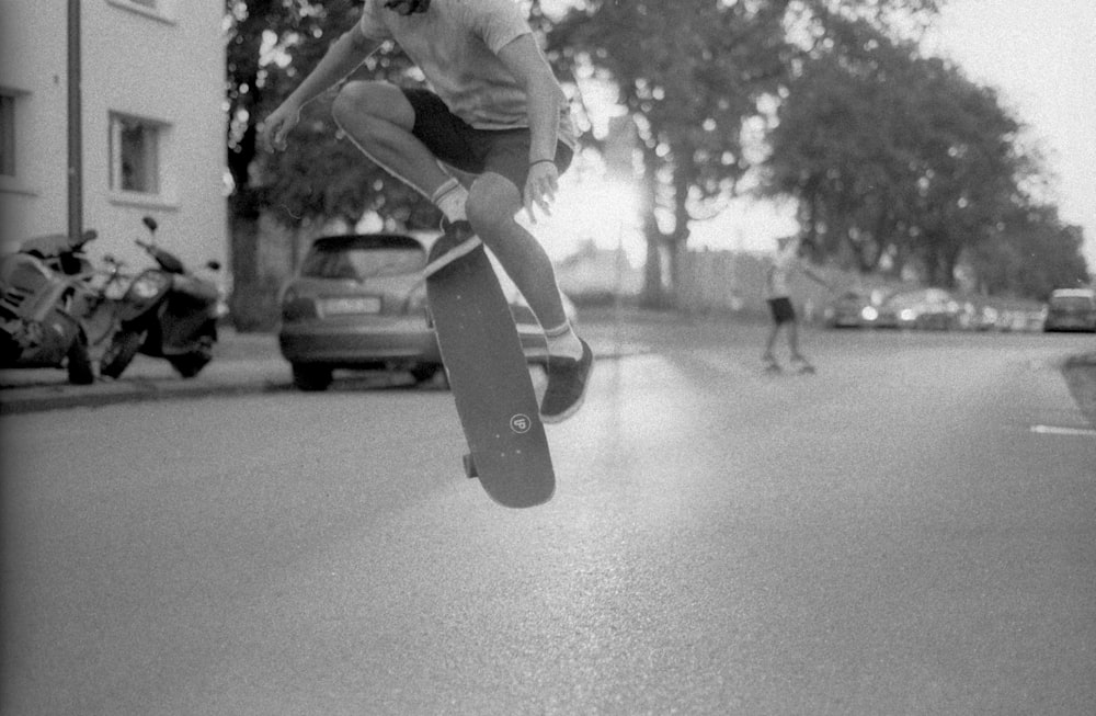 grayscale time-lapse photography of man doing skateboard trick