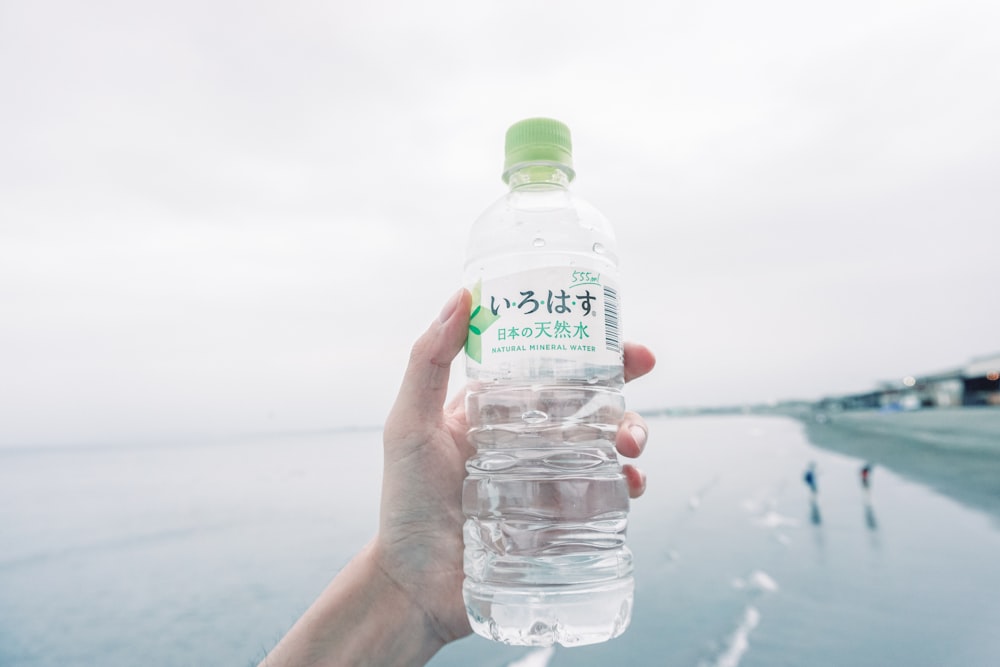 person holds plastic bottle