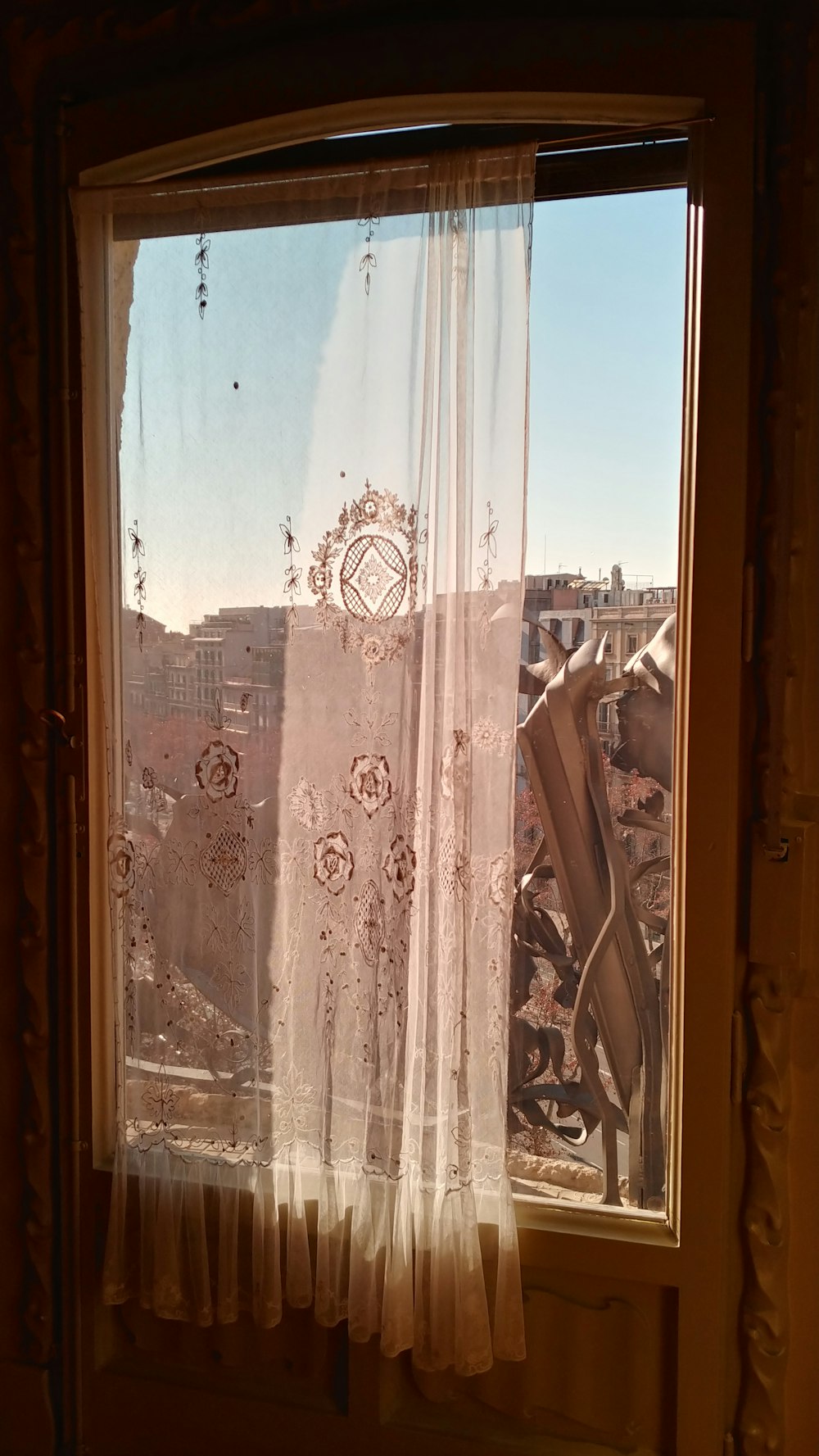 rideau transparent suspendu à une porte semi-éclairée