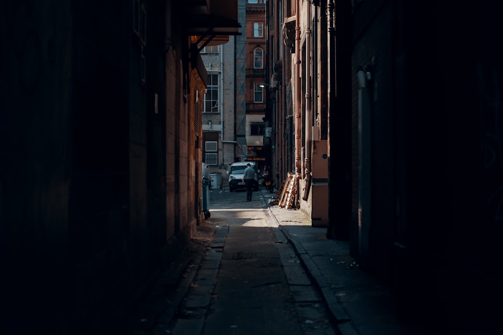 person walking beside building near vehicle