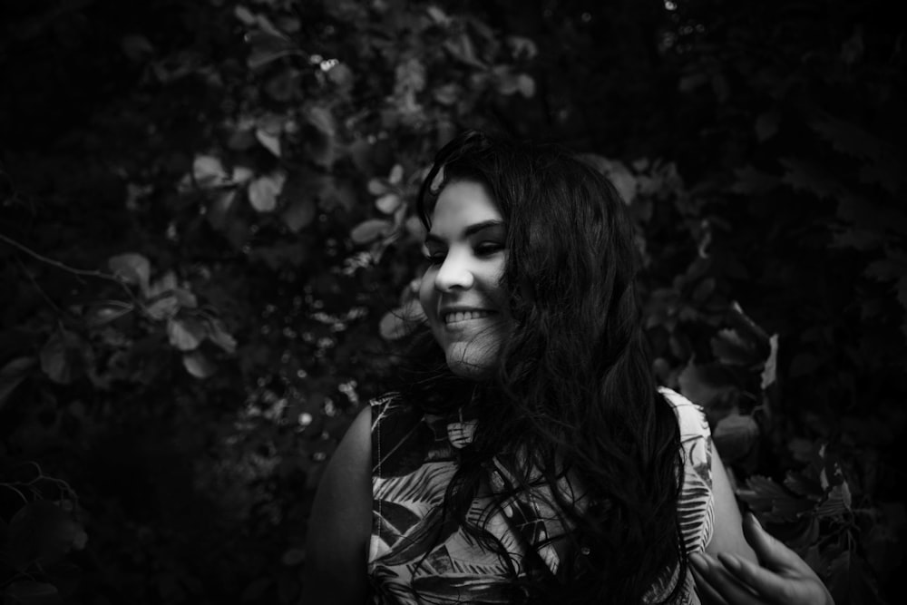 grayscale photography of woman surrounded by plants