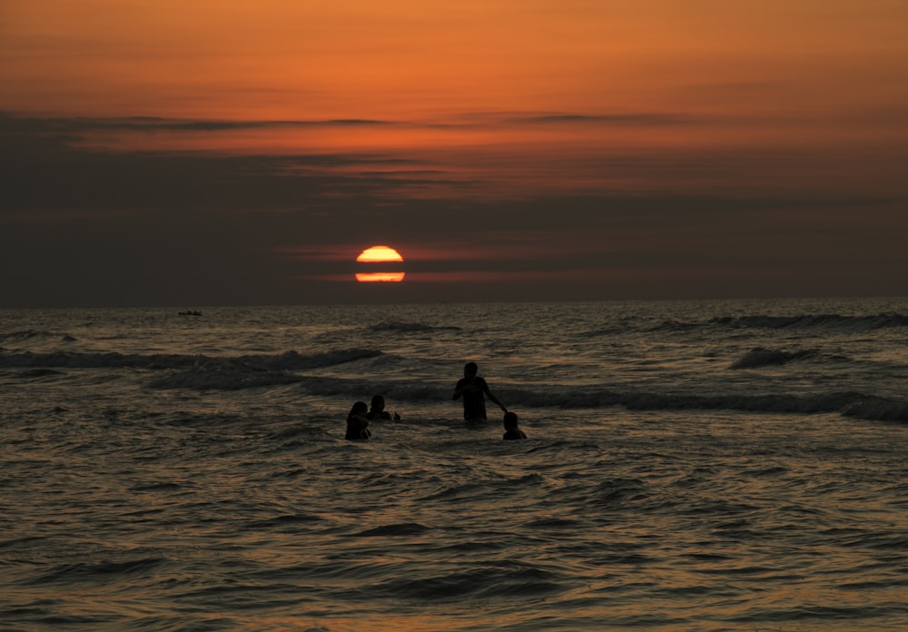 Silhouette von vier Personen am Strand