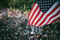 A vibrant gathering of Trump supporters holding American flags at a community event.