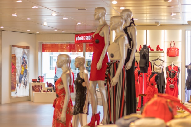 A vibrant display of ladies' dresses, handbags, and kids' outfits arranged on mannequins and hangers.