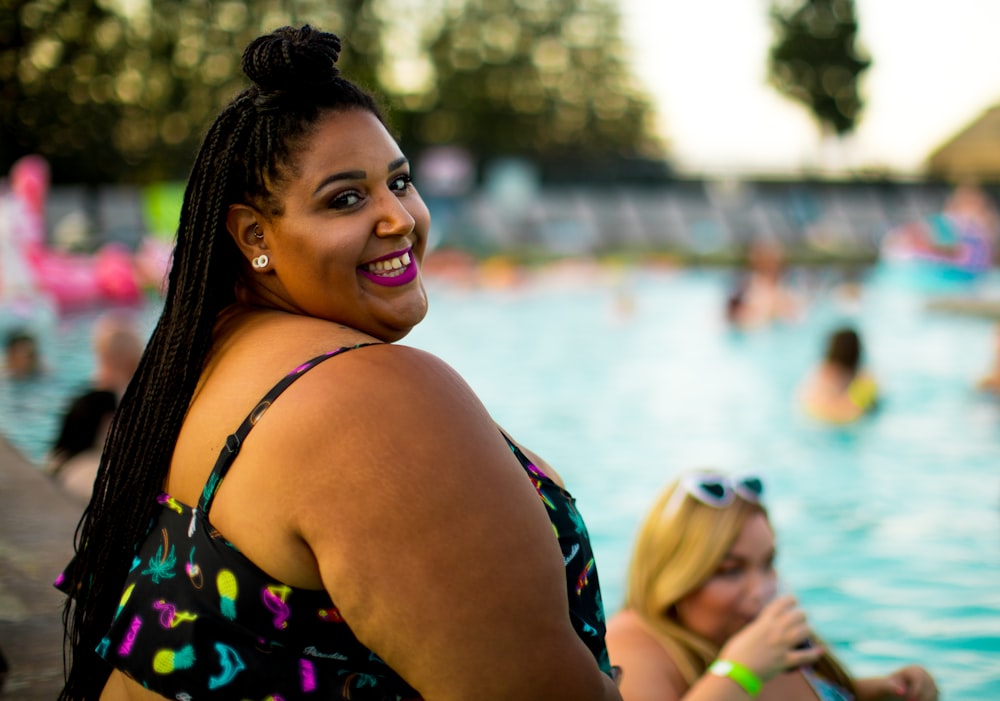 mulher sorridente ao lado da piscina