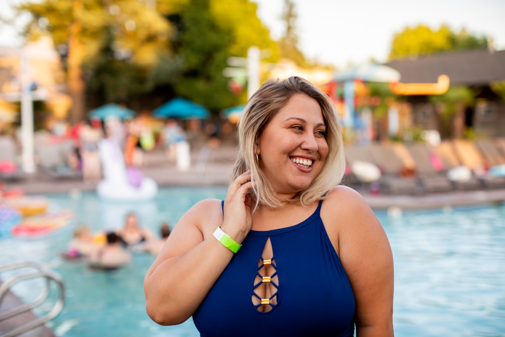 woman wearing blue bikini top holding blonde hair