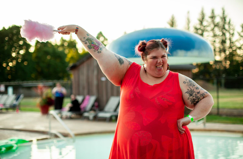 Radiant BBW woman in red dress by the pool