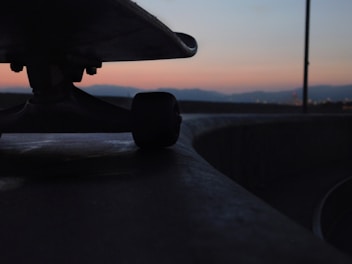 Close-up of colorful longboard wheels rolling on rough pavement.