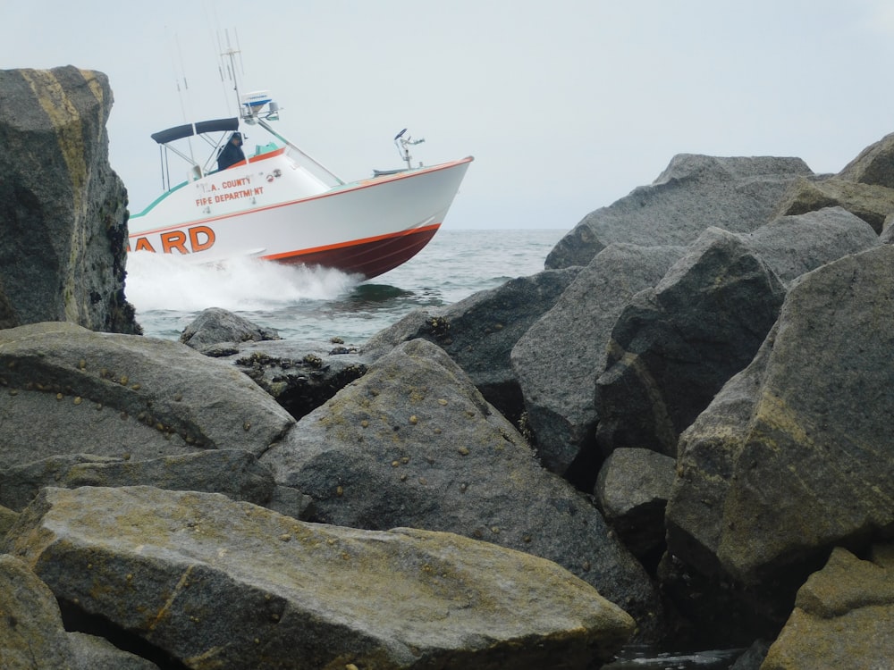 rock chunks across white and orange boat