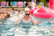 A joyful family enjoying a sunny day at the pool, all wearing colorful swimwear.