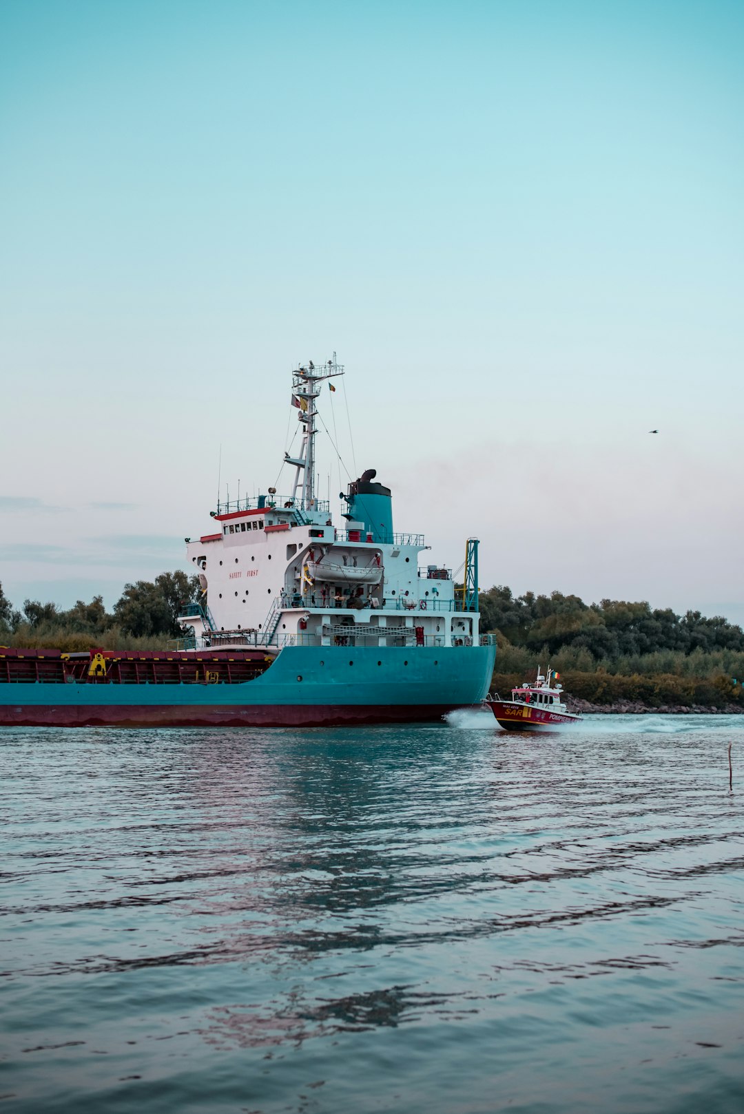 small boat near cargo ship