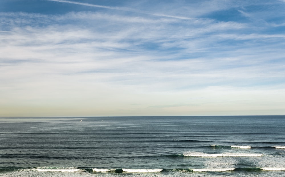 water waves under white clouds