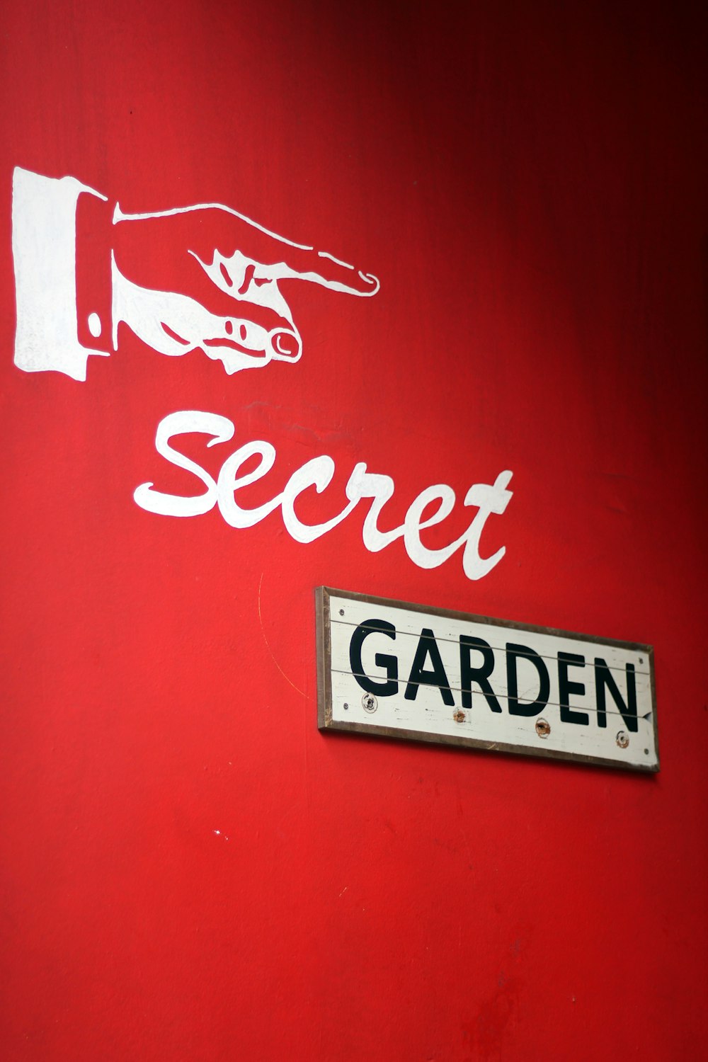 a sign on the side of a building that says secret garden