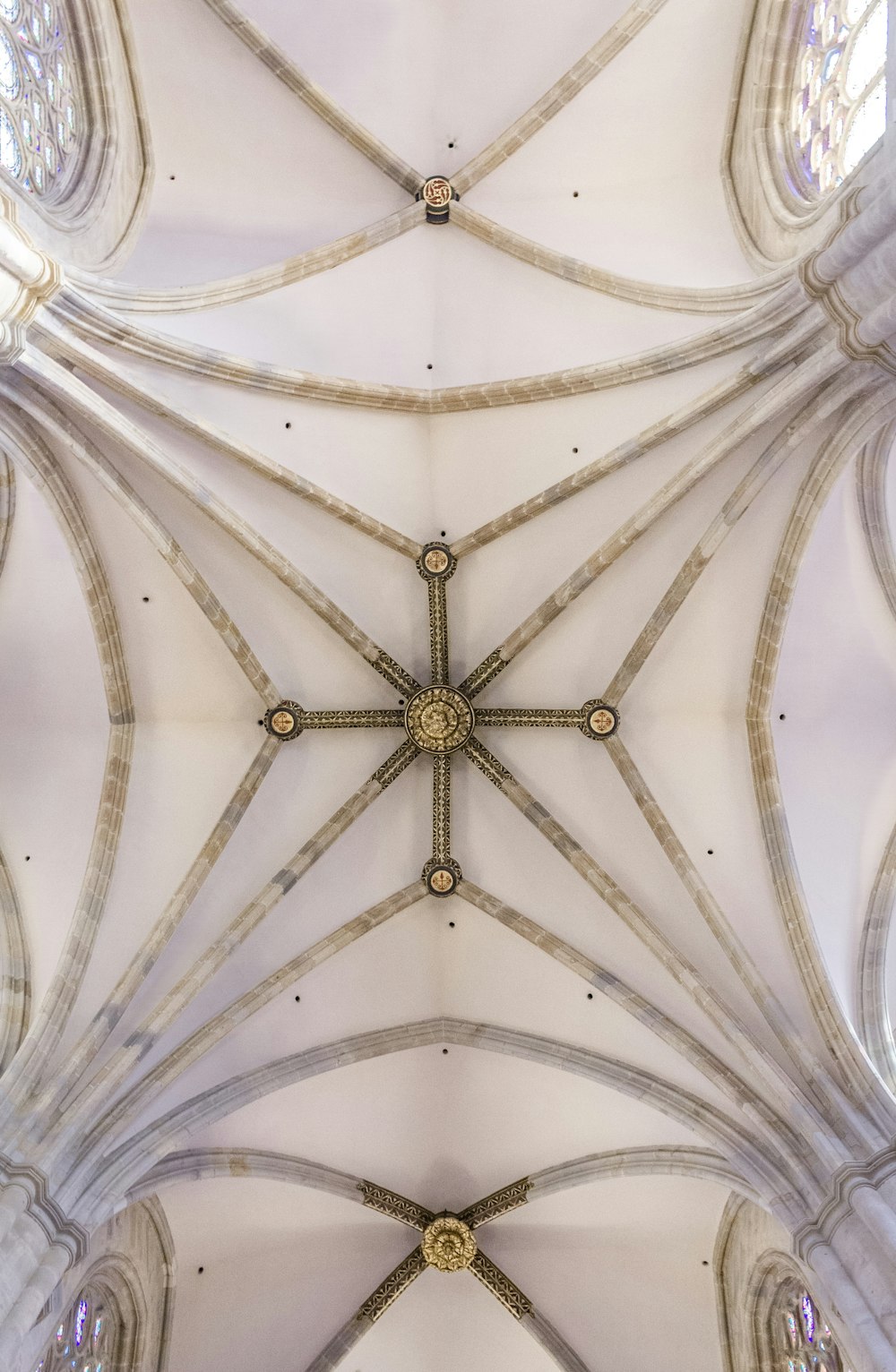 the ceiling of a cathedral with a cross in the middle