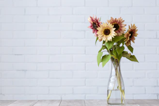 Bright sunlit bouquet of sunflowers arranged elegantly on a wooden table.
