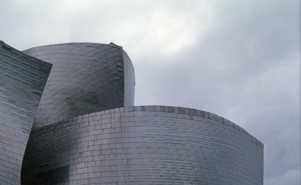 low angle photography of glass building under cloudy sky