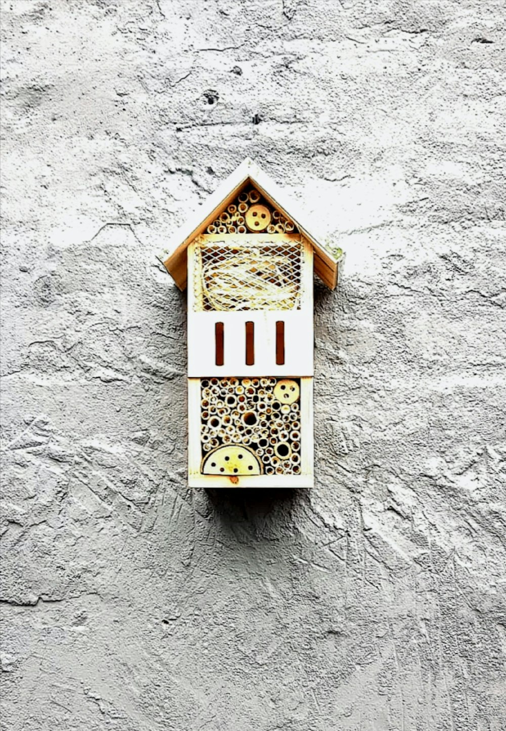 white and brown wooden bird cage on wall
