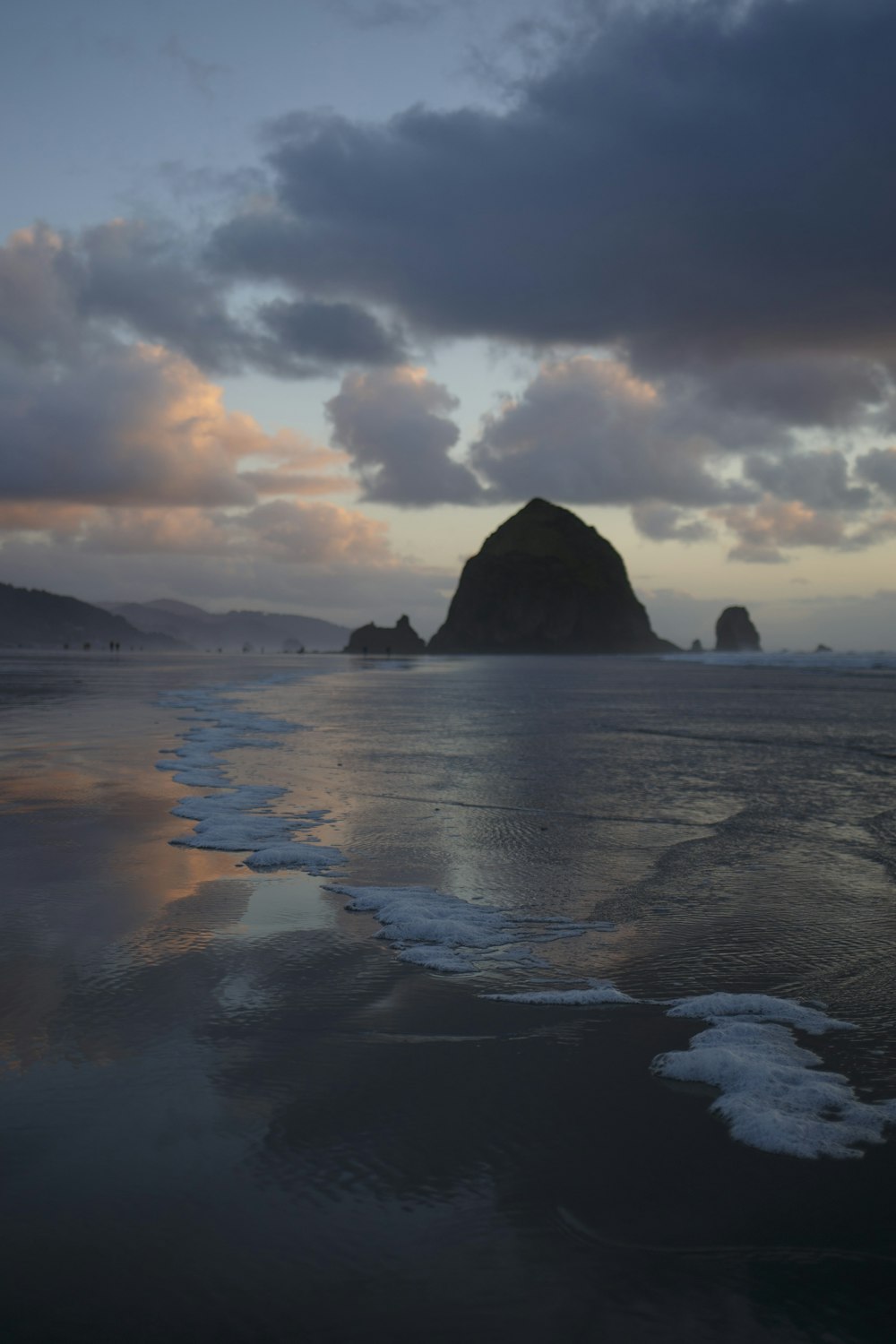 seashore near rocky mountain at daytime