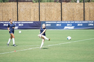 Students playing soccer together on the school field during practice.