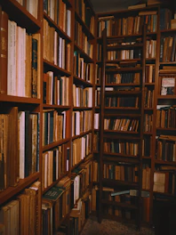 books stacked on wooden shelves in a library