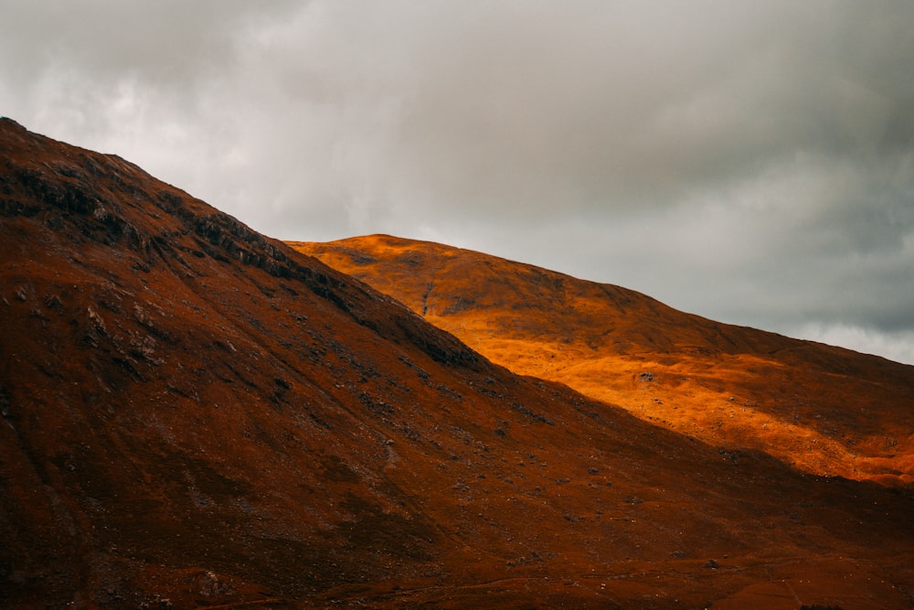 brown mountain under gray sky