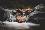 Close-up of crystal-clear water flowing gently over smooth natural stones.